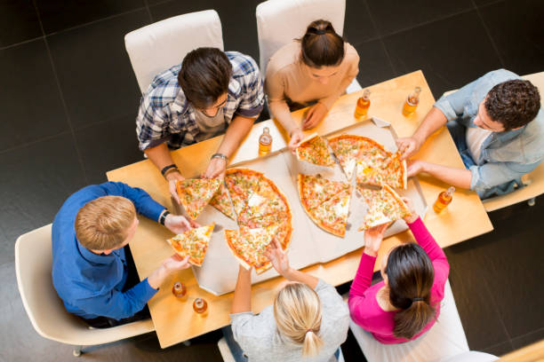 istock Group of young people eating pizza and drinking cider 934048490