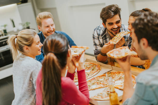istock Group of young people eating pizza and drinking cider 934048500