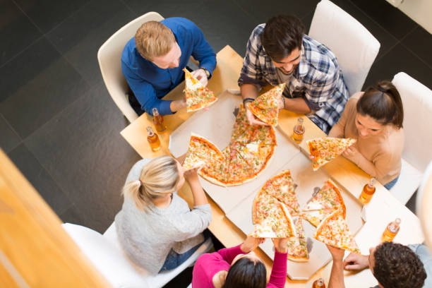 istock Group of young people eating pizza and drinking cider 934048504