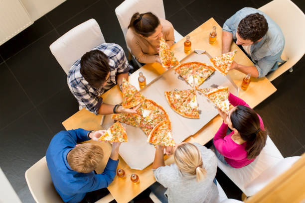 istock Group of young people eating pizza and drinking cider 934048516
