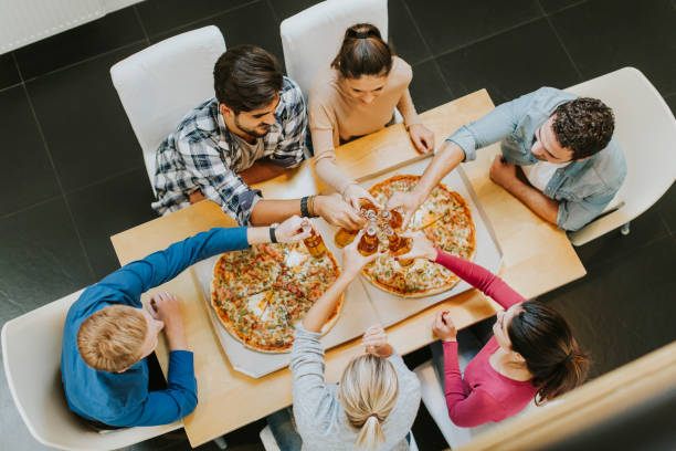 istock Group of young people eating pizza and drinking cider 934048526