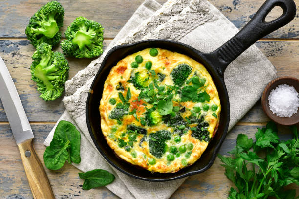 Spring omelette with green vegetables (broccoli, sweet pea and spinach) in a skillet