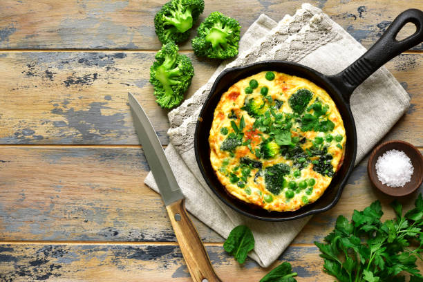 istock Spring omelette with green vegetables (broccoli, sweet pea and spinach) in a skillet 934053542