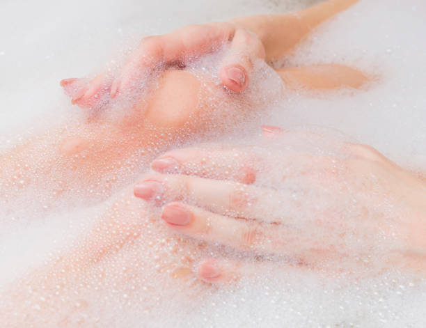 istock Beautiful female feet and hands in white soap bath. Selective focus, close-up. 934070910