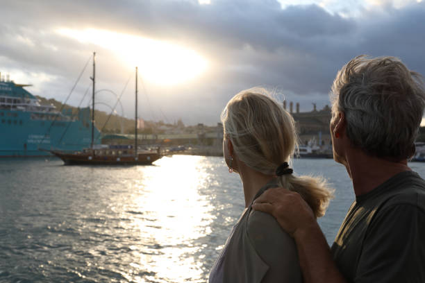 istock Couple look out over city harbour at sunrise 934070980