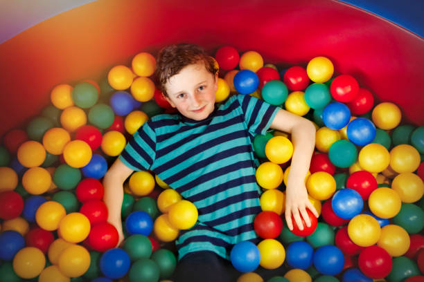 istock Young boy playing in the pool with plastic balls 934071246