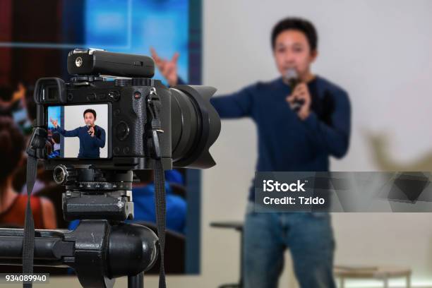 Professional Digital Mirrorless Camera With Microphone On The Tripod Recording Video Blog Of Asian Speaker On The Stage Seminar Camera For Photographer Or Video And Technology Live Streaming Concept Stock Photo - Download Image Now