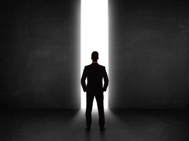 istock Business person looking at wall with light tunnel opening 934095718