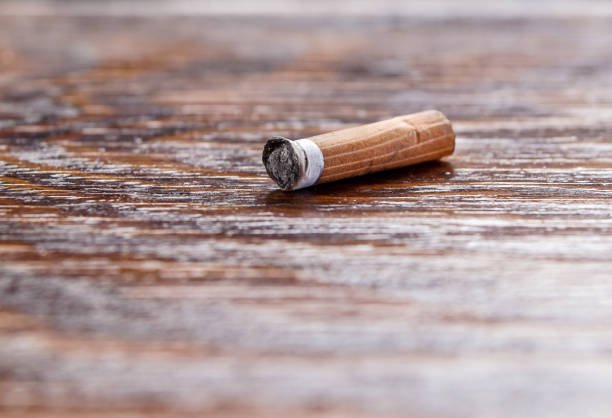 istock used cigarette on the wooden table. Selective and close focus 934098940