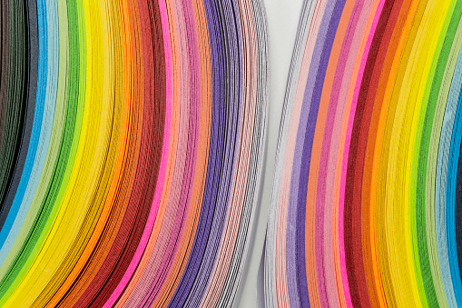 Multicolored quilling paper curved stripes forming a bright background. quilling rainbow colors, close-up, Colorful abstract lines for background.