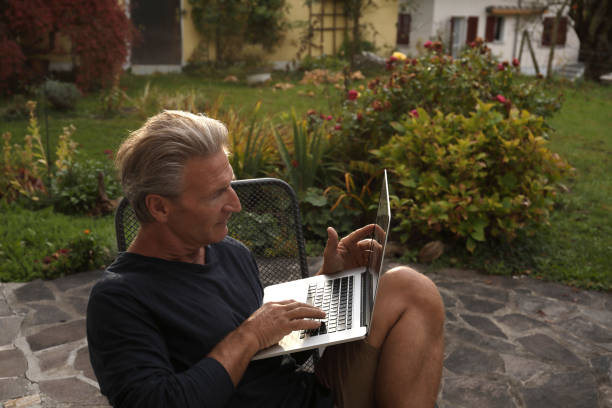 istock Man works on laptop computer in garden 934104902
