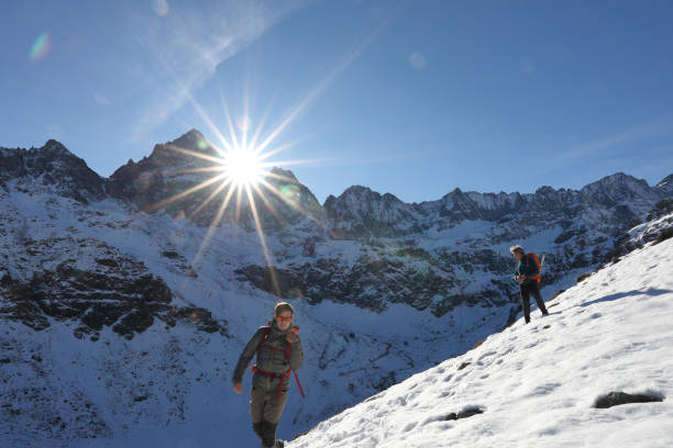 dois montanhistas decend da cimeira e montanhas cobertas de neve - 18638 - fotografias e filmes do acervo