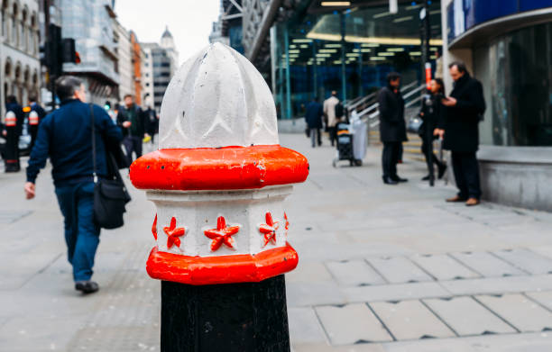 enfoque selectivo sobre un pivote en la ciudad de londres, con trabajadores de la ciudad en el fondo - traffic cone uk street london england fotografías e imágenes de stock