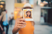 Woman showing instant photo to the camera