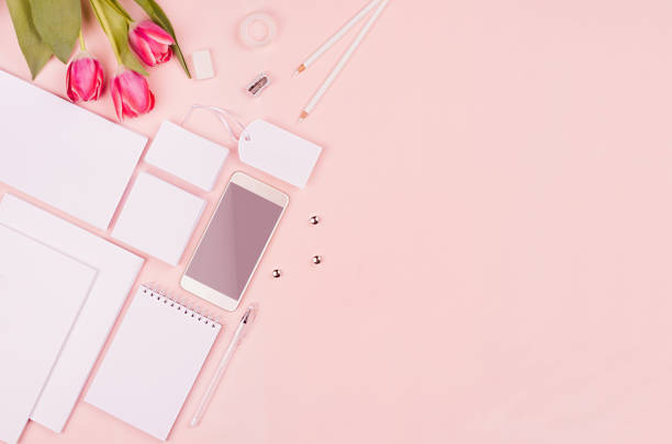 istock Modern minimalistic spring workspace with white blank stationery, tulips flower on soft pastel pink background, top view, copy space. 934133262