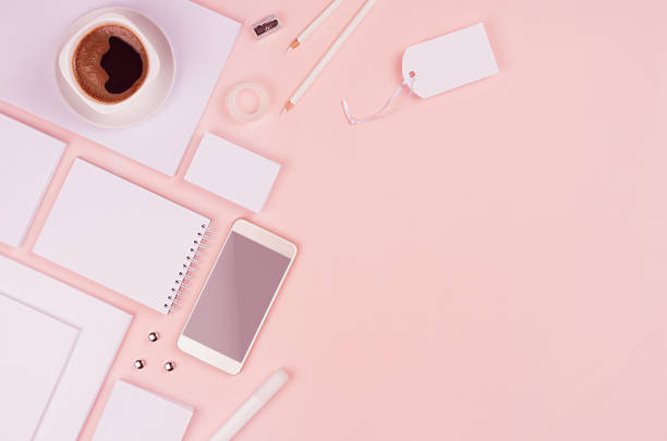 istock Stylish working space with coffee cup, phone and blank white stationery on pastel soft pink background, copy space. Template for your design. 934133302