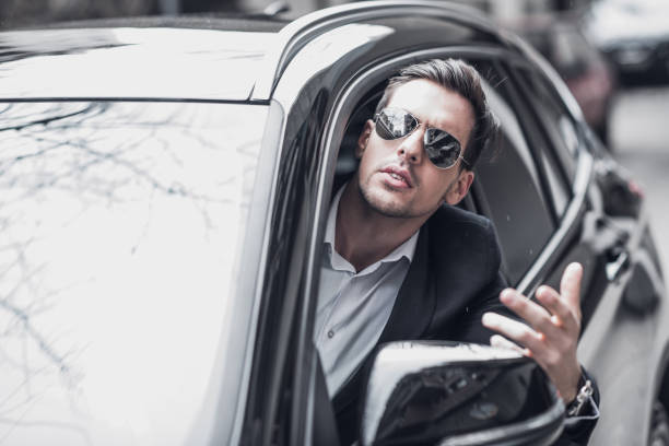 istock Nervous businessman looking through a car window 934139028