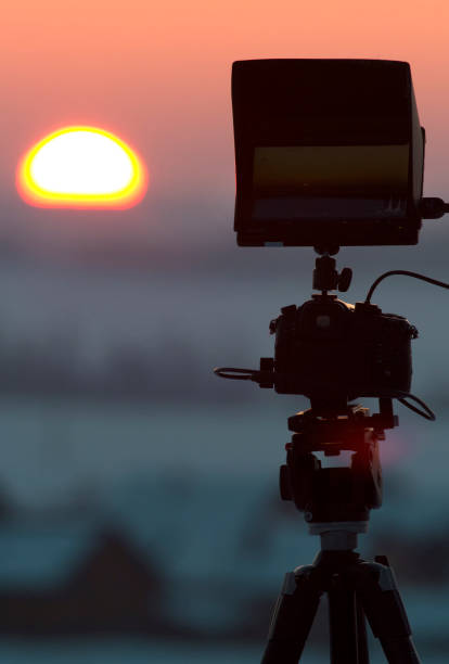 istock Silhouette of camera on tripod shooting beautiful winter sunrise 934142292