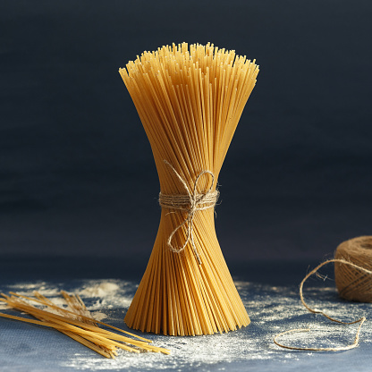 Bunch of uncooked Italian pasta spaghetti on a blue background