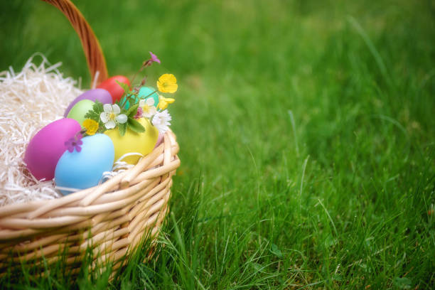 istock Basket with colorful eggs on green springtime grass 934150592