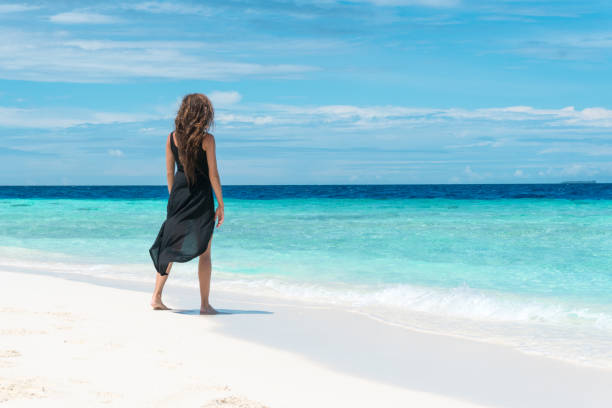 istock Woman walking on beach in Maldives 934150904