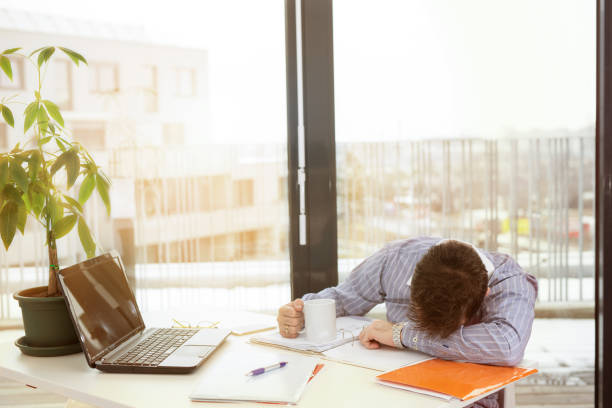 istock Young tired businessman sleeping at the office desk 934186880