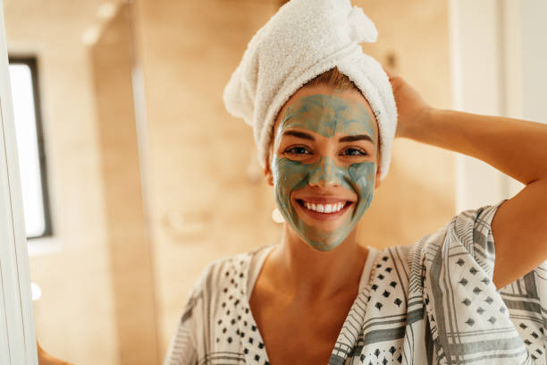 Taking care of my skin Attractive young woman standing in the bathroom with a facial mask green clay stock pictures, royalty-free photos & images