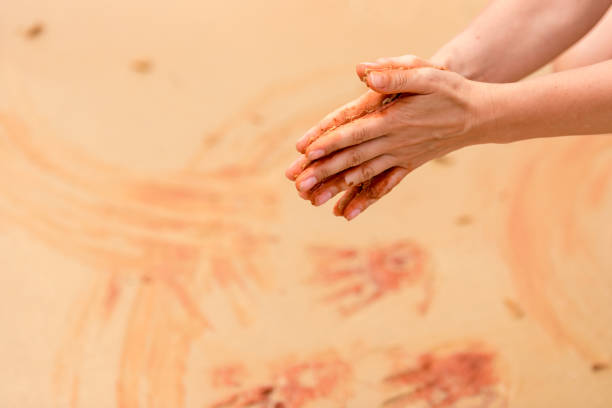 女性の手のアボリジニのアート スタイルのビーチで赤い砂で図形を作成します。 - aboriginal art australia indigenous culture ストックフォトと画像