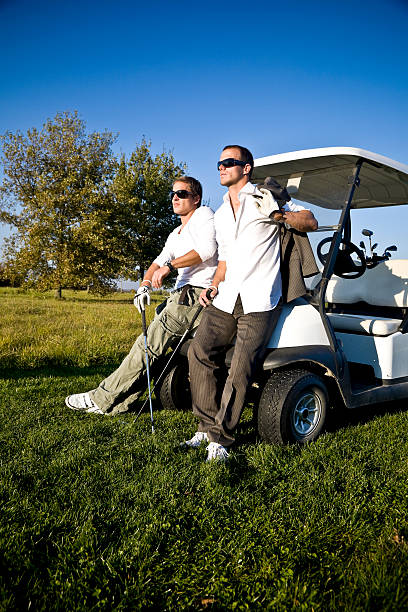 après le travail, le parcours de golf - golf cart golf mode of transport transportation photos et images de collection