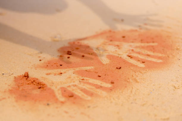 red soil hand shape on sand in aboriginal art style - aborigine imagens e fotografias de stock