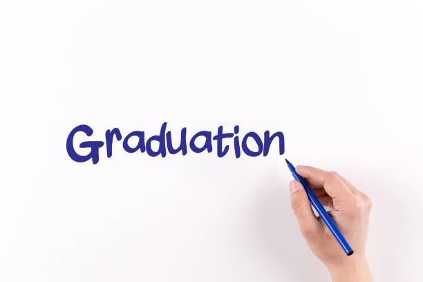 istock Hand writing GRADUATION on white paper, View from above 934224690