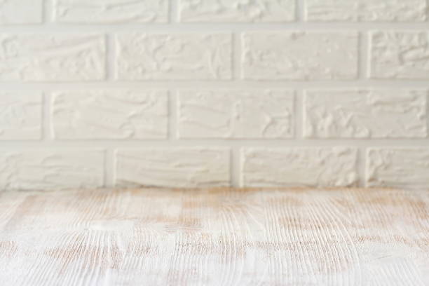 istock White wooden table with a brick wall as a background 934230520