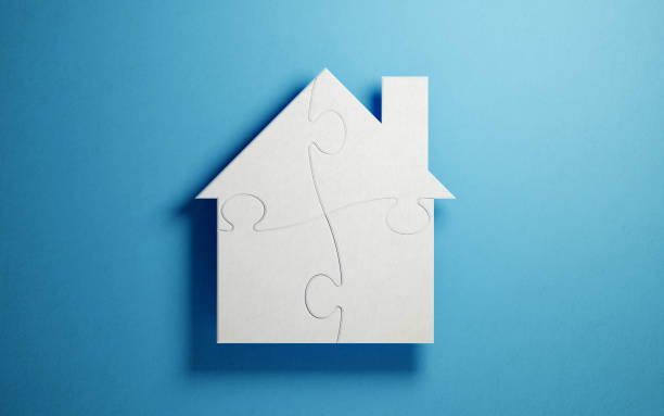 istock Puzzle Concept - White Jigsaw Puzzle Pieces Forming A House Shape On Blue Background 934246126