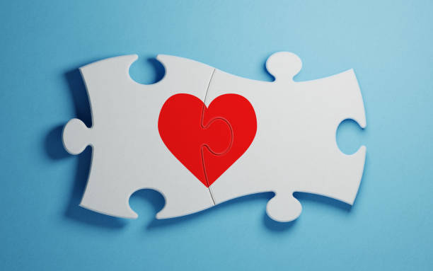 istock Puzzle Concept - White Jigsaw Puzzle Pieces Forming A Red Heart On Blue Background 934248354