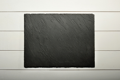 Black Stone Plate on White Wood Background