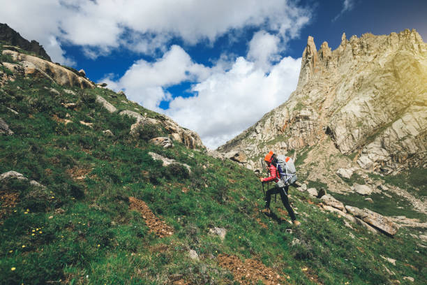 young woman with backpack hiking in mountains