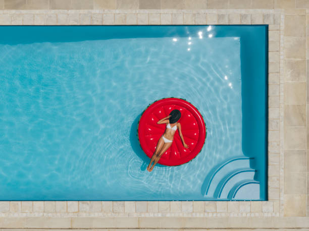 istock Female sunbathing on floating mattress in pool 934251706