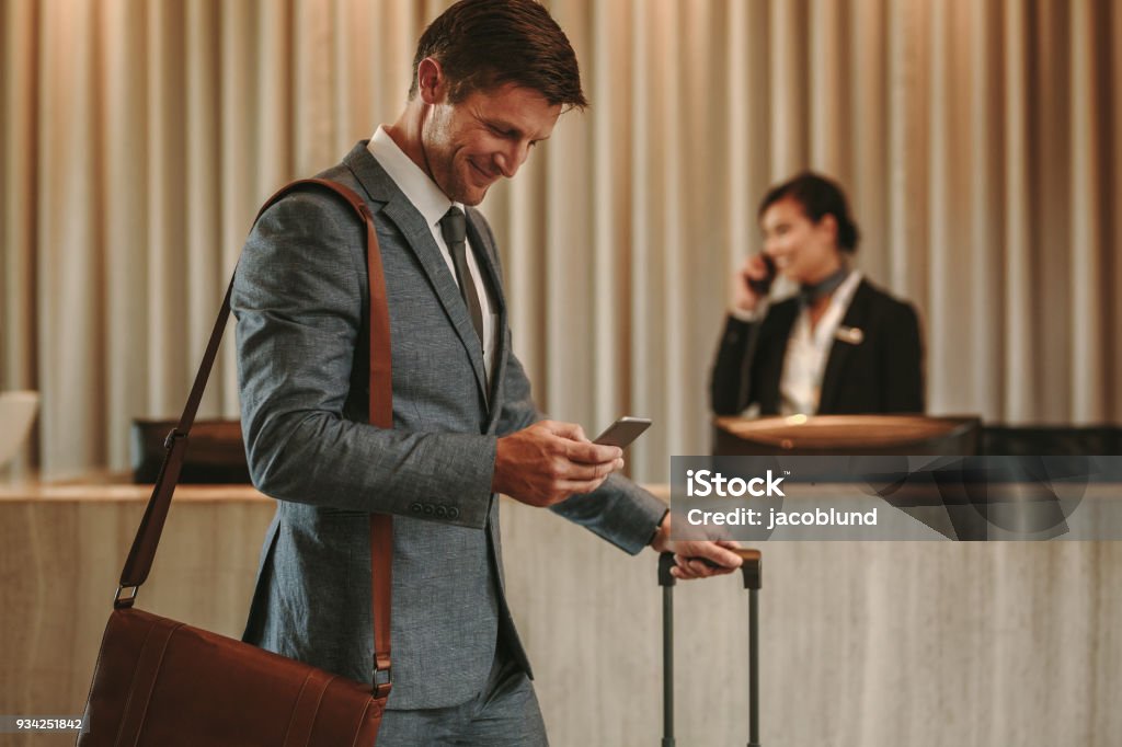 Geschäftsmann im Hotel Flur mit Handy und Gepäck - Lizenzfrei Hotel Stock-Foto