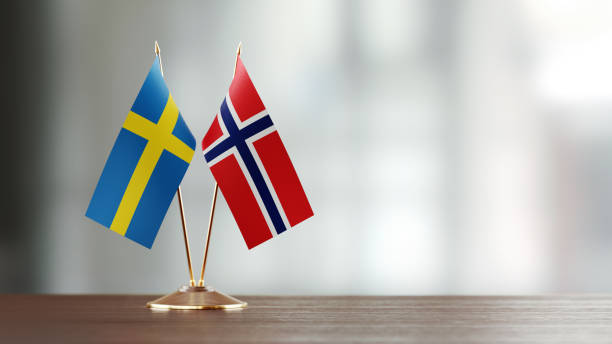 istock Swedish And Norwegian Flag Pair On A Desk Over Defocused Background 934256582