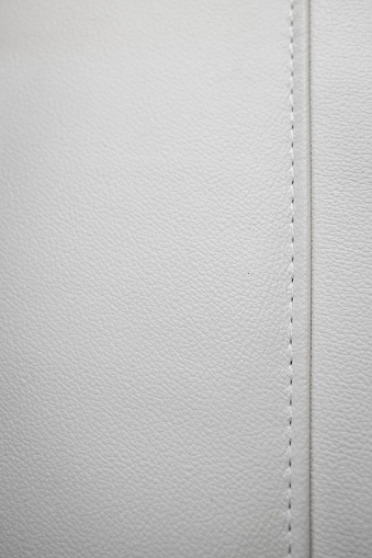 White leather texture with seams in close-up as a background