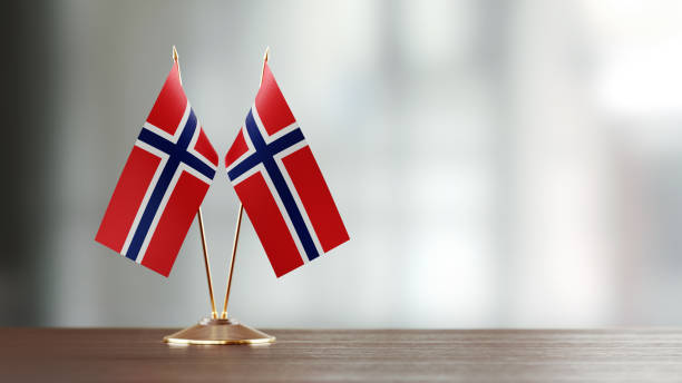 istock Norwegian Flag Pair On A Desk Over Defocused Background 934258762