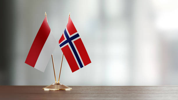 istock Indonesian And Norwegian Flag Pair On A Desk Over Defocused Background 934259308