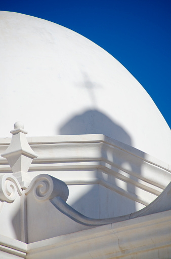 The San Xavier del Bac Mission stands on the Tohono O'odham Indian Reservaton near Tucson, Arizona.  The building itself is full of interesting architectural details.  Pictured here is a shadow cast by a tower with a cross onto the dome of the chapel.