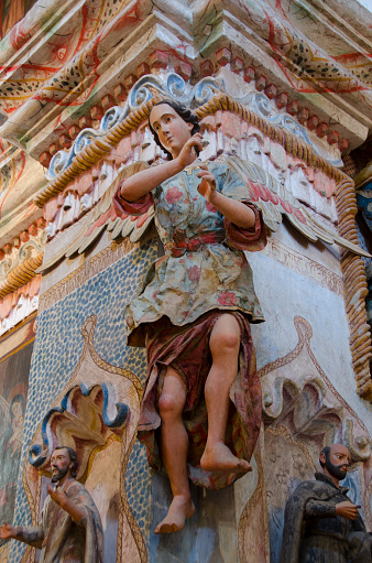 An angel figurine hangs from a column inside the San Xavier del Bac Mission near Tucson, Arizona.