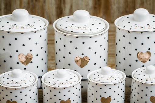 Black dotted white porcelain spice jars with heart pattern on brown background