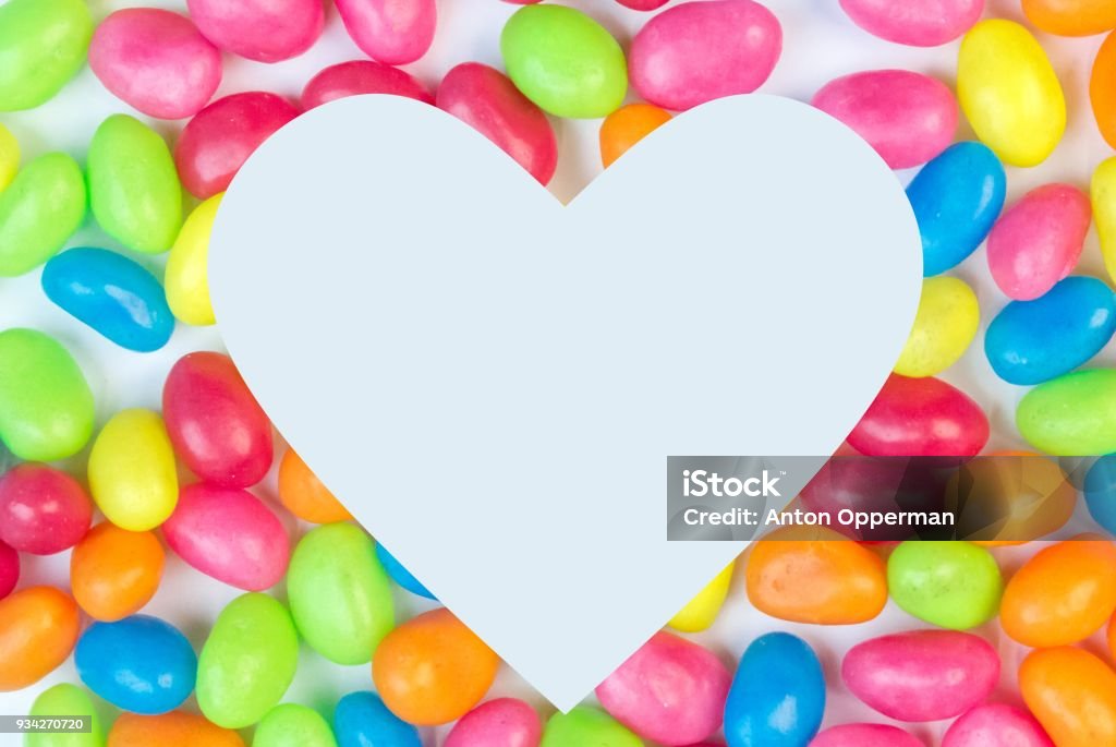 Bunte Jelly Bean Hintergrund mit weißen herzförmigen Platz für - Lizenzfrei Bunt - Farbton Stock-Foto