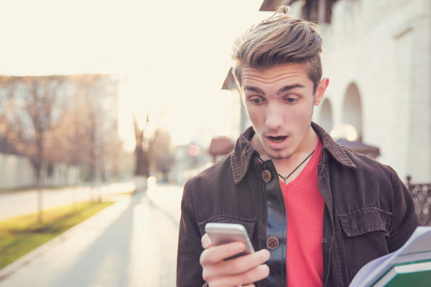 istock Shocked man watching phone on street 934270998