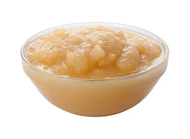 Applesauce in a Glass Bowl isolated over a white background.  The image is in full focus from front to back and includes a clipping path.  This fruity sauce is used as a side dish at meals.  It can also be used as an ingredient in many recipes.