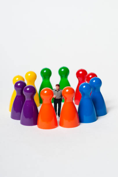 istock Colourful pawns encircling a toy figure 934281012