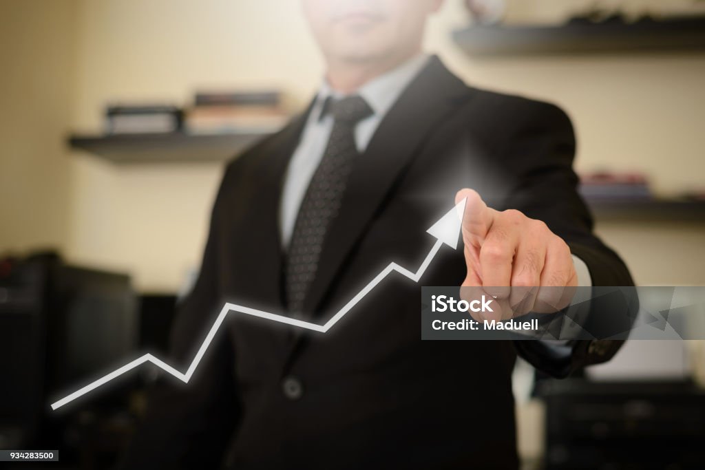 Business man showing growth chart This image represents positive thinking and plans for financial growth, success and victory Achievement Stock Photo